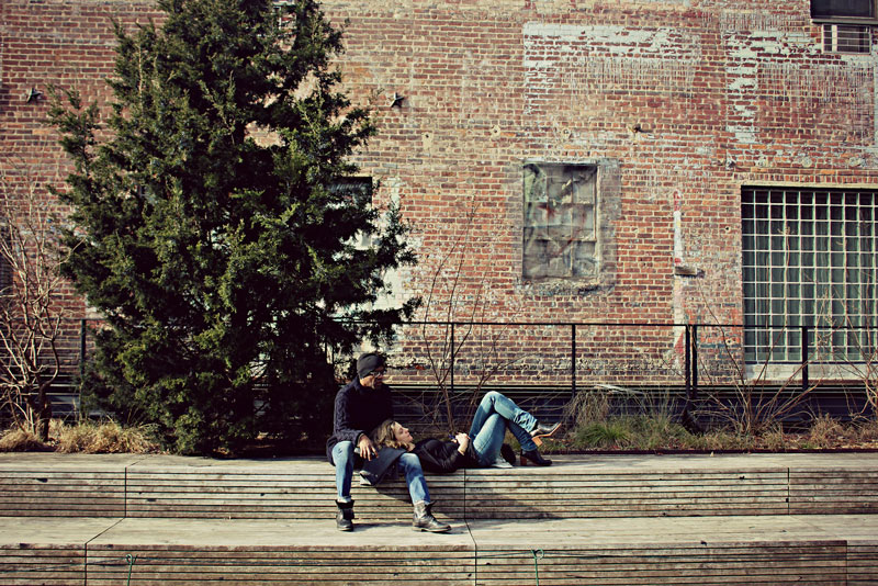 A couple lounge on some outdoor stairs while discussing what CBD does to the brain