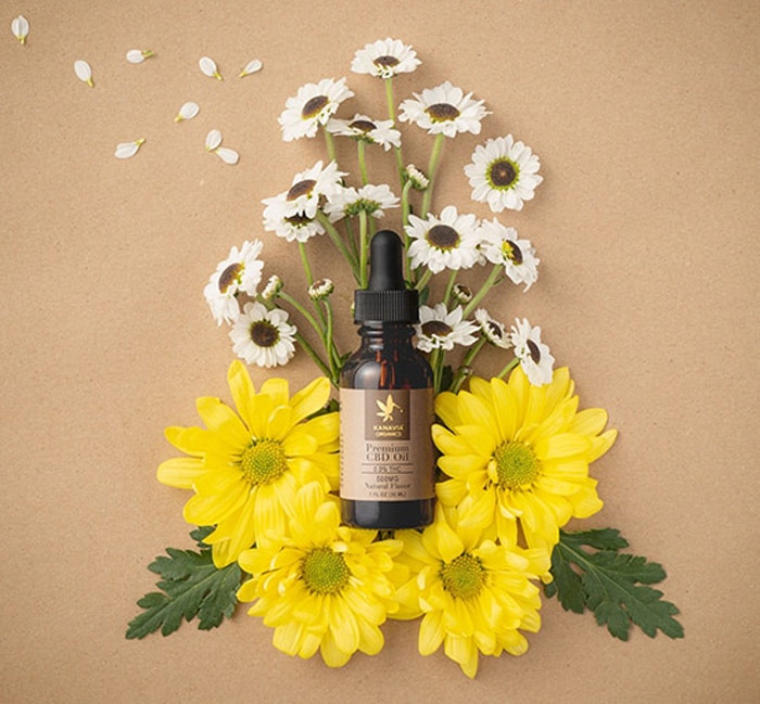 A bottle of Kanavia medicinal hemp with fresh-cut flowers.